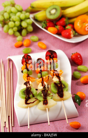 Gli spiedini di frutta con il cioccolato. Ricetta disponibile. Foto Stock