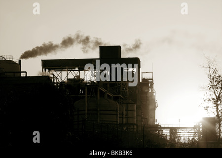 Retroilluminazione industria petrolchimica fumo smog su sky Foto Stock