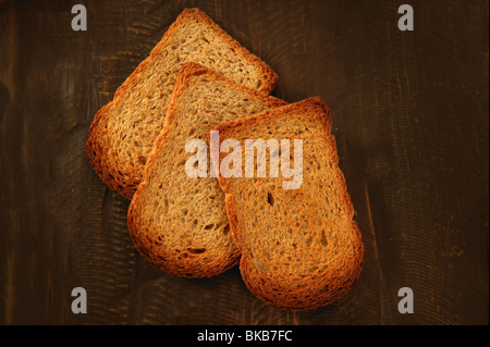 Fette di pane su un vecchio legno scuro dello sfondo Foto Stock