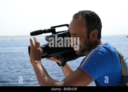 Uomo egiziano riprese con videocamera, Mar Rosso, Egitto Foto Stock