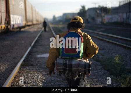 Una centrale non documentate migrante americano in viaggio per lavoro negli Stati Uniti attende lungo i binari della ferrovia in Città del Messico. Foto Stock