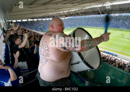 Il canto il batterista per gli appassionati e i tifosi di calcio a Leicester City Football Club, batte il suo bass drum ad una casa di gioco Foto Stock