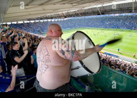 Il canto il batterista per gli appassionati e i tifosi di calcio a Leicester City Football Club, batte il suo bass drum ad una casa di gioco Foto Stock