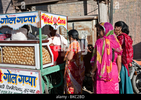 Le donne indiane acquisto di pani puri (snack indiano). Bikaner. Il Rajasthan. India Foto Stock