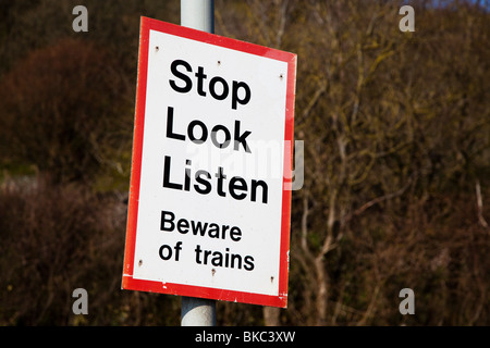 Smettere di guardare ascoltare attenzione dei treni segno di avvertimento sulla linea ferroviaria St Ishmaels Pembrokeshire Wales UK Foto Stock