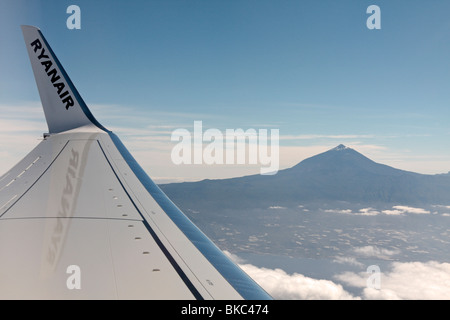 L'ala di un Ryanair Boeing 737-800 visto di fronte il monte Teide per il suo approccio a Tenerife nelle Isole Canarie Spagna Foto Stock