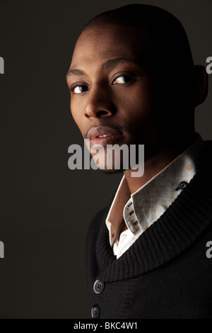 Giovani professionisti dell'Africano nero imprenditore per adulti in un abito nero con una fascetta rosa Foto Stock