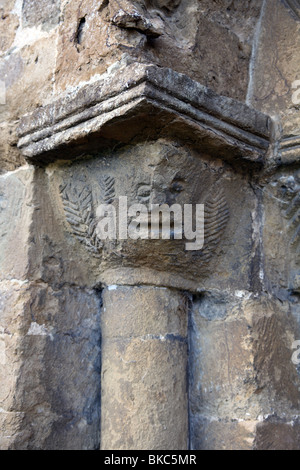 Capitale del cuscino con una scultura di un uomo di colore verde, Norman Sud porta, Chiesa di San Lorenzo, Oxhill, Warwickshire Foto Stock