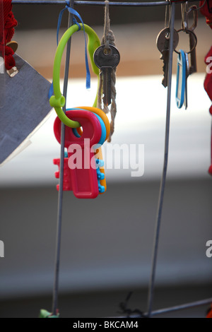 Una serie di giocattoli per bambini tasti in plastica appendere su una barriera come parte di una più ampia protesta contro la mancanza di progresso a L'Aquila Foto Stock