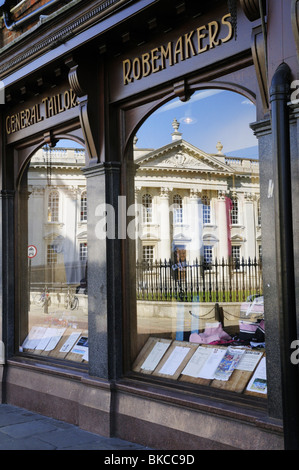 La Casa del Senato riflessa nella vetrina del negozio di Ryder e Amies generale sarti e Robemakers, Inghilterra Cambridge Regno Unito Foto Stock