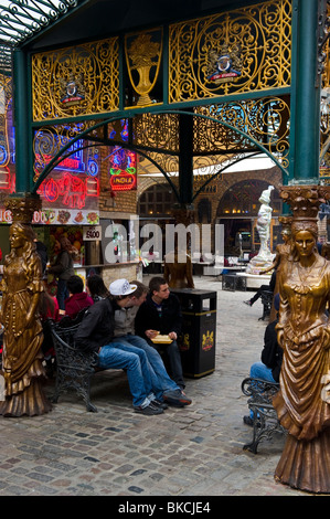 Un gruppo di giovani seduti a cavallo maneggio ospedale parte del mercato di Camden Market North London REGNO UNITO Foto Stock