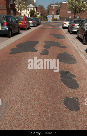 Fori riparati in strada, riempitivo asfalto nero in re, asfalto rosa Foto Stock