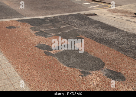 Fori riparati in strada, riempitivo asfalto nero in re, asfalto rosa Foto Stock