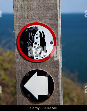 Pericolo cliff simbolo di bordo su Pembrokeshire Coast path Wales UK Foto Stock