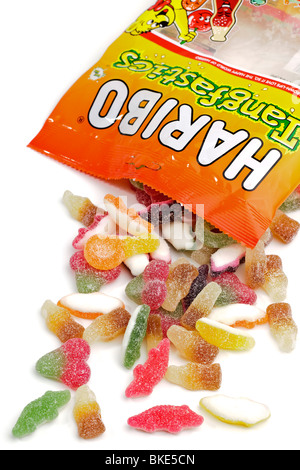 Il sacchetto in plastica di Haribo Tangfastics rivestite di zucchero masticare caramelle riversandosi su di una superficie bianca Foto Stock