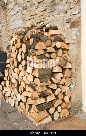 Legna da ardere impilati al di fuori di una porta cottage in Yorkshire Dales. Foto Stock