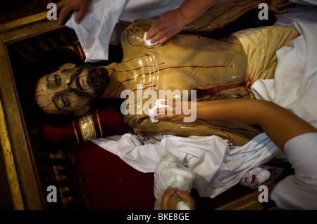 Le donne sfregano olio su una statua di Gesù Cristo dopo una settimana Santa processione in Oaxaca, Messico, 11 aprile 2009. Foto Stock