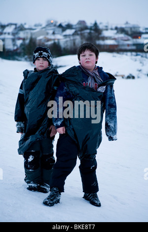 Due ragazzi in posa per la telecamera in caso di neve. Hafnarfjordur, una maggiore area di Reykjavik, Islanda Foto Stock