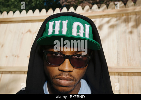 African American uomo in occhiali da sole e cappello e felpa con cappuccio Foto Stock