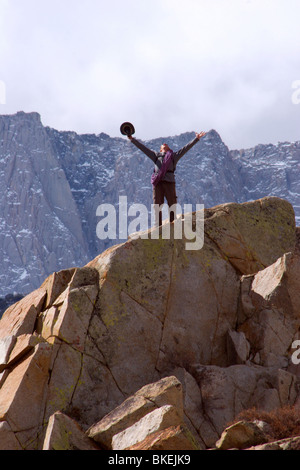 L'uomo celebra dopo il raggiungimento di una pietra miliare sulla sua montagna salita Foto Stock