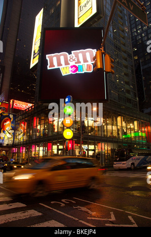 New York taxi attraversa nella parte anteriore del M E M S world store, Times Square Manhattan, New York Foto Stock