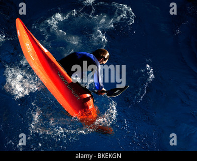 Freestyle Whitewater Kayaker cartwheeling un arancio kayak, Ulm, Baden-Wuerttemberg, Germania Foto Stock