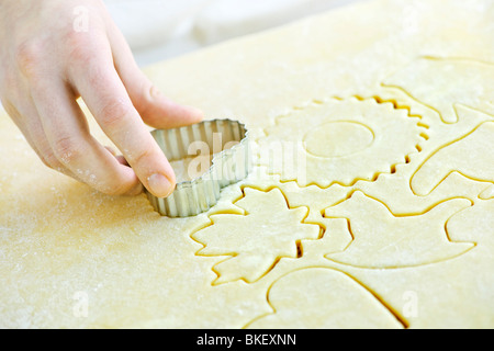 Il taglio di forme dei cookie in impasto arrotolato con taglierina Foto Stock