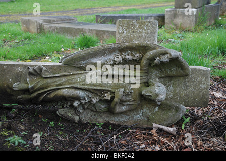 Una lapide raffigurante un angelo su una croce, rovesciato per la salute e per ragioni di sicurezza. Foto Stock