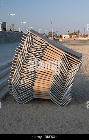 Pila di sedie a sdraio sulla spiaggia la sera su una spiaggia di Barcellona Foto Stock