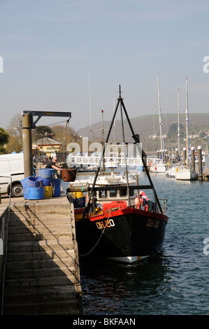 Caricamento Off stock ittici sulla banchina a Dartmouth South Devon England Regno Unito il blu di barili contengono acqua di mare granchi memorizzata Foto Stock