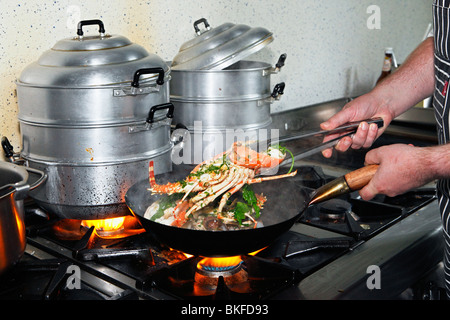 Uno chef che prepara un piatto di frutti di mare Foto Stock