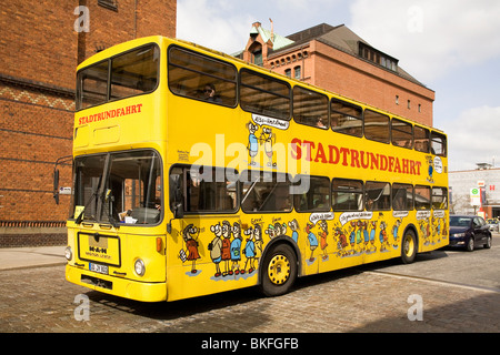 Un giallo double-decker bus fornisce un tour della città di Amburgo, Germania. Foto Stock