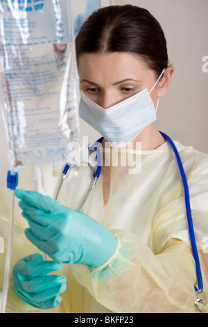 Ritratto di lavoratore di cura di salute controllo fluido IV borsa nel centro dialisi a. Foto Stock