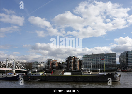 Barche di occupare i loro posti barca sul fiume Tamigi visto dal Cheyne a piedi nel Quartiere di Chelsea, appartment blocchi occupano il lato sud. Foto Stock