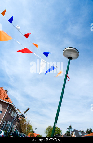 Una strada nella città olandese di Veenendaal decorate con bunting nella celebrazione del Re giorni di vacanza su Aprile 27 Foto Stock