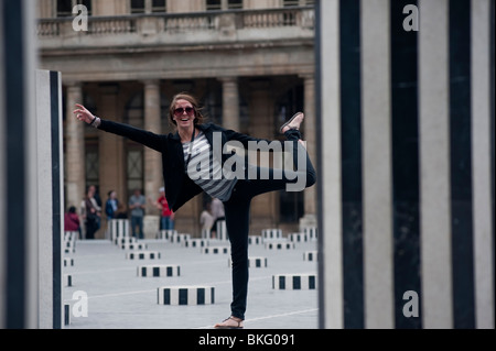 Palais Royale giardini, Jardins, ragazza in posa park, 'colonnes de buren' scultura moderna installazione, Parigi, Francia Foto Stock