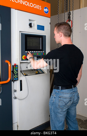 Un ingegnere di programmazione di un CNC di erosione a filo macchina per la lavorazione di componenti in acciaio. Foto Stock