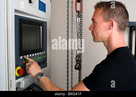 Un ingegnere di programmazione di un CNC di erosione a filo macchina per la lavorazione di componenti in acciaio. Foto Stock