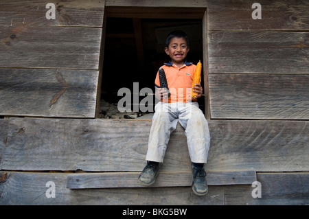 Bambino guatemalteco nella parte anteriore del granaio dove il grano è immagazzinato Solola dipartimento Guatemala Foto Stock