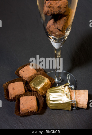 Il lusso del commercio equo tartufi Champagne, spolverato con polvere di cacao in flûte di champagne. Foto Stock