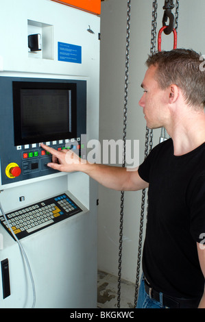 Un ingegnere di programmazione di un CNC di erosione a filo macchina per la lavorazione di componenti in acciaio. Foto Stock