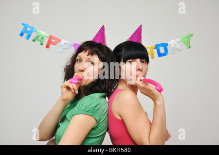 Due giovani donna rumore di soffiaggio soffiante Foto Stock