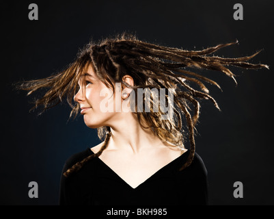 Studio shot ritratti di una bionda e giovane donna caucasica con dreadlocks su sfondo nero Foto Stock