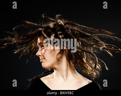 Studio shot ritratti di una bionda e giovane donna caucasica con dreadlocks su sfondo nero Foto Stock