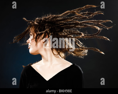 Studio shot ritratti di una bionda e giovane donna caucasica con dreadlocks su sfondo nero Foto Stock