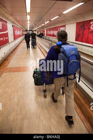 Il passeggero spingendo il carrello con i bagagli attraverso l'aeroporto di Gatwick di Londra Inghilterra REGNO UNITO Foto Stock