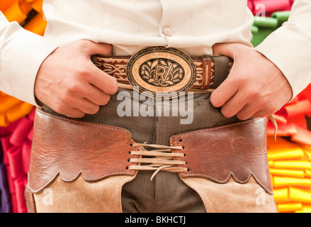 Guadalajara, Messico, Charro (Cowboy messicano) con mani appoggiate sulla fibbia della cintura di sicurezza e chaps, Club Lienzo Charro, Jalisco Foto Stock