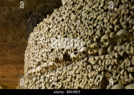 Teschi decorano il tunnel sotterraneo delle catacombe di Parigi Foto Stock