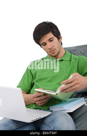 Studente - il giovane uomo con notebook lettura libro seduti sul bean bag su sfondo bianco Foto Stock