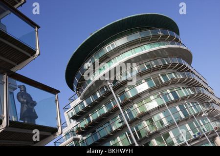 Architettura moderna a Londra, Wapping contrasta con la figura di un bronzo scultura cinese su un balcone adiacente. Foto Stock